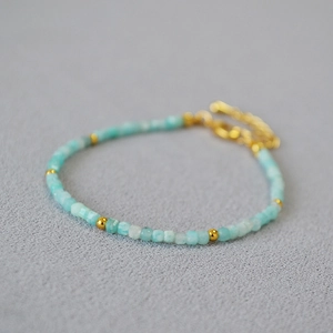 Detail of light blue gemstone bead bracelet with gold spacer beads and lobster clasp
