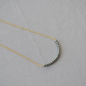 Minimalist gold chain necklace with curved grey pearls for daily elegant commute style