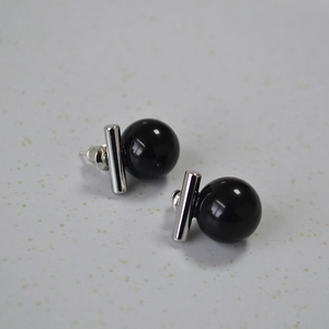 Détail montrant les perles d'onyx noir et les boucles d'oreilles barre en argent