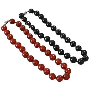 Retro beaded necklace set with large red agate and black obsidian stones on white background