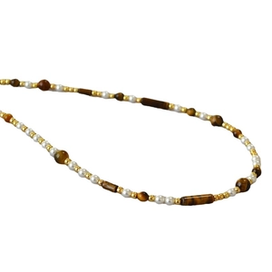 Vintage necklace with brown tiger eye stones and white pearls on white background