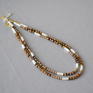 Détail du collier double rang perlé avec œil de tigre et nacre de style bohème