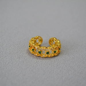 Detailed view of hollow lattice ring with green zircon stones and sparkling diamonds