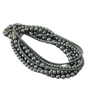 Multi-layer dark grey pearl necklace with metallic luster and silver buckle on white