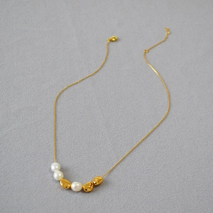 Macro shot of minimalist choker with baroque freshwater pearls and irregular gold beads