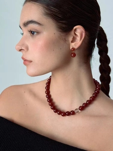 Close-up of red agate and white crystal beaded necklace with matching earrings on model