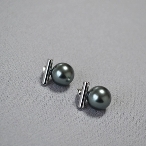 Gros plan sur les boucles d'oreilles en argent 925 avec perles noires et barre en T minimaliste