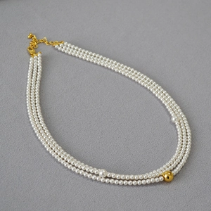 Three-layer white pearl necklace with elegant gold bead accent and lobster clasp