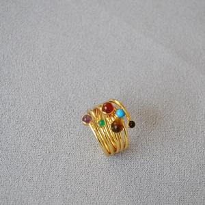 Multi-layer gold plated brass spiral ring with six colorful natural stones on gray background
