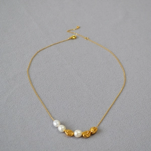 Detail of 18K gold necklace with baroque pearls and irregular golden beads on fine chain