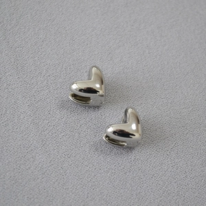 Vue détaillée de boucles d'oreilles cœur en argent poli au design minimaliste