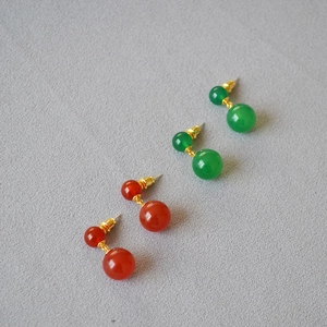 Detail of red and green agate bead drop earrings with 925 silver needles and gold accents