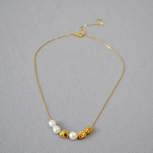 Baroque freshwater pearl necklace with irregular gold beads on a delicate chain