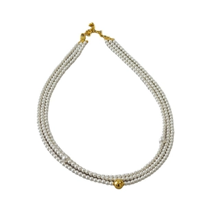 Elegant triple-layer pearl necklace with central gold bead and adjustable chain