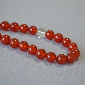 Detail of red agate beads and clear crystal bead on elegant necklace jewelry