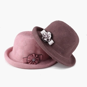 Detail of crocheted knit cloche hats with decorative fabric flowers and crystal accents