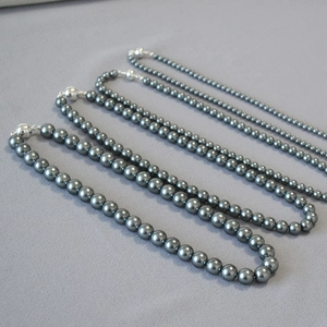 Detail showing four grey pearl necklaces with silver magnetic clasps in various sizes