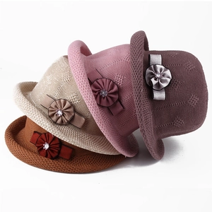 Detail of four colorful knit sun hats with floral ribbon bows and rhinestone accents