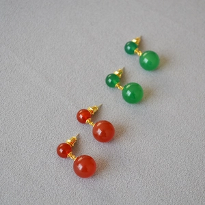 Detail of red and green agate double ball drop earrings with golden chain links