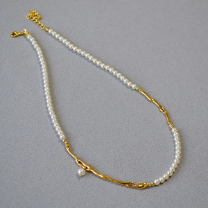 Détail du collier de perles et branche dorée avec fermoir mousqueton ajustable
