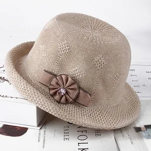 Elegant dark beige knit sun hat with floral bow detail on a fashion magazine