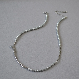 Détail du collier de perles avec branches argentées et fermoir mousqueton sur tissu