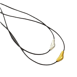 Minimalist gold and silver teardrop pendants on black leather cord necklace