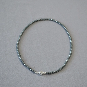 Detailed view of dark Tahitian style pearls with a spherical silver magnetic clasp closure