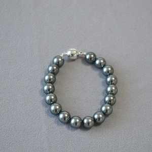 Detailed view of dark grey Tahitian style pearls with a silver magnetic spherical clasp