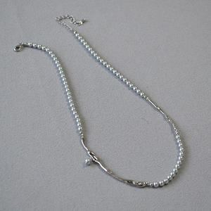 Détail du collier de perles grises avec pièce en métal argenté et fermoir mousqueton réglable