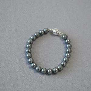 Close-up of dark grey pearls with metallic luster and silver magnetic ball clasp