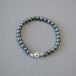 Macro shot of 8mm dark grey pearl beads with silver spherical magnetic clasp detail