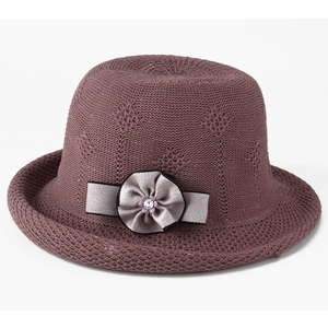 Detail of hollow knit purple sun hat featuring a decorative ribbon and crystal floral accent