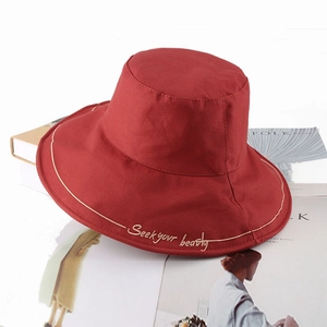 Deep red cotton bucket hat with gold embroidery on books for stylish sun protection