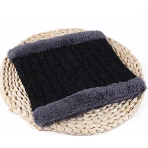 Detail view of black chenille neck warmer with thick grey fleece lining on straw mat