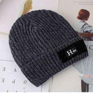 Detailed view of gray knit beanie with vintage H patch on a fashion magazine