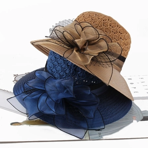 Detail showing hand-woven straw hats with elegant large organza floral and mesh decor