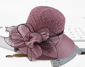 Close-up of pink knitted summer hat with layered organza flower and mesh detail