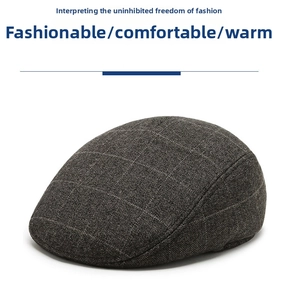 Detail showing high-quality wool blend fabric and dark grey plaid pattern on warm flat cap
