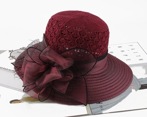 Detail of burgundy knitted sun hat with organza floral accent and mesh veil