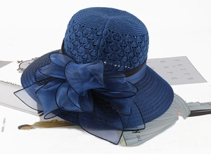 Detailed macro view of dark blue hollow crochet sun hat with large organza bow decoration