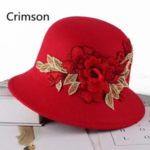 Detail of elegant red cloche hat with large 3D rose embroidery and floral texture