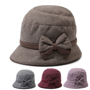 Detail of wool cloche hats with bow accents in brown, burgundy, and purple colors