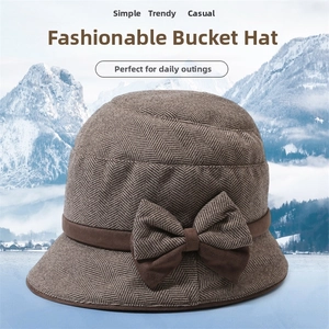 Detail of brown herringbone wool bucket hat featuring a vintage bow and thick texture