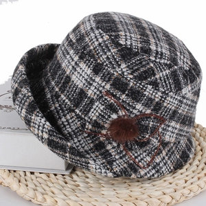 Détail d'un chapeau cloche d'hiver à carreaux avec motif floral sur support tressé