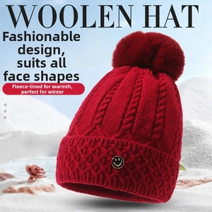 Detail der roten Strickmütze mit Fleece-Futter und großem Bommel für Damen im Winter