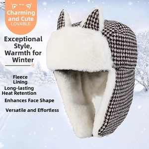 Detailed close-up of cat-ear bomber hat showing warm white faux fur and houndstooth pattern