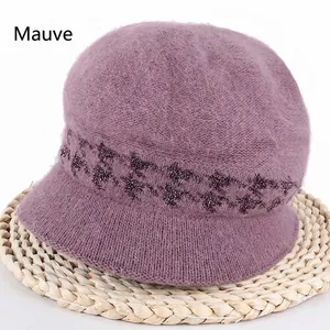 Winter knitted mauve bunny fur hat with sequins on a natural straw mat backdrop