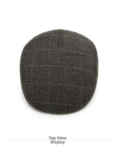 Top down view of a dark grey plaid newsboy cap with warm wool blend texture