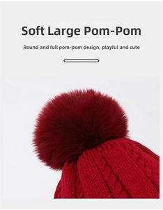 Detailansicht einer roten Strickmütze mit einem großen flauschigen Kunstfell-Bommel